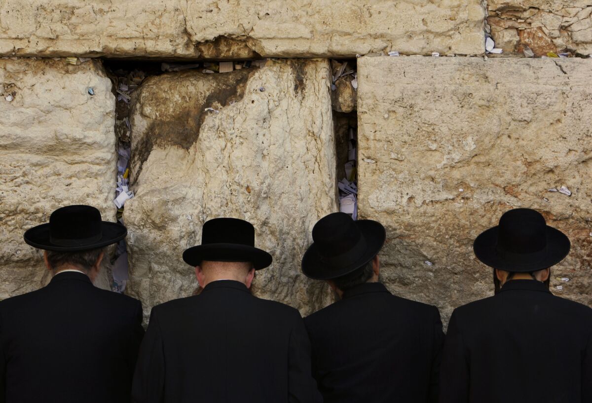 Men face the Western Wall as they pray in Jerusalem.