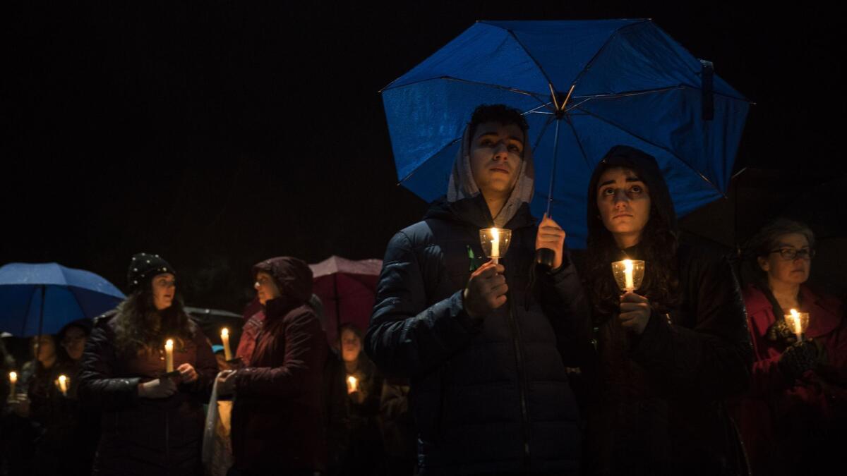 Mourners hold candles as they attend a community vigil at Newtown High School in Connecticut for the victims of the mass shooting at Marjory Stoneman Douglas High School in Parkland, Fla.