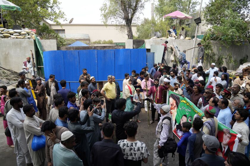 Supporters of former Prime Minister Imran Khan gather outside of the Khan house in Lahore, Pakistan, Sunday, March 19, 2023. Police in the Pakistani capital filed charges Sunday against former Prime Minister Imran Khan and 17 of his aides and scores of supporters, accusing them of terrorism and several other offenses after the ousted premier's followers clashed with security forces in Islamabad the previous day. (AP Photo/K.M. Chaudary)