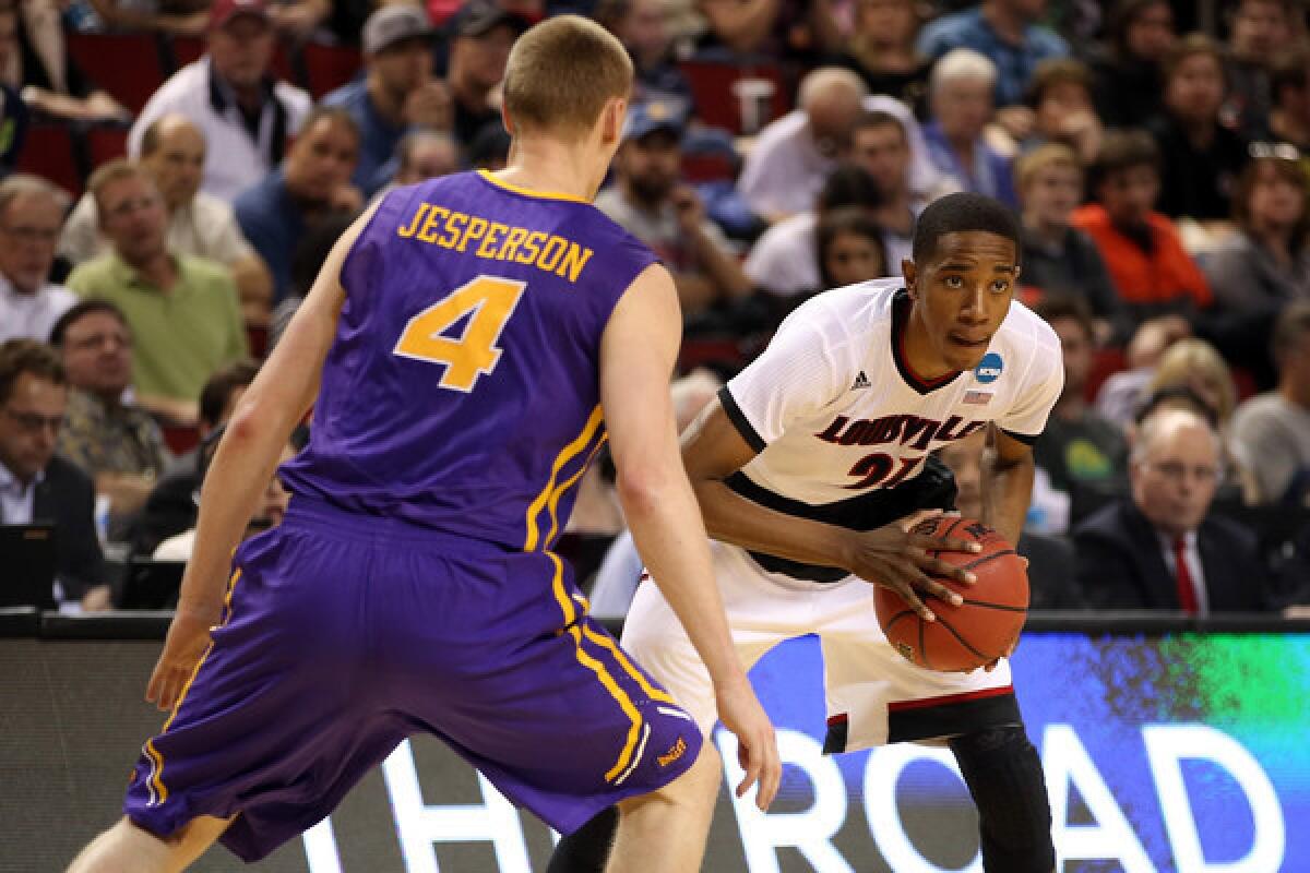 Louisville's Shaqquan Aaron looks to pass against Iowa's Paul Jesperson on March 22, 2015.