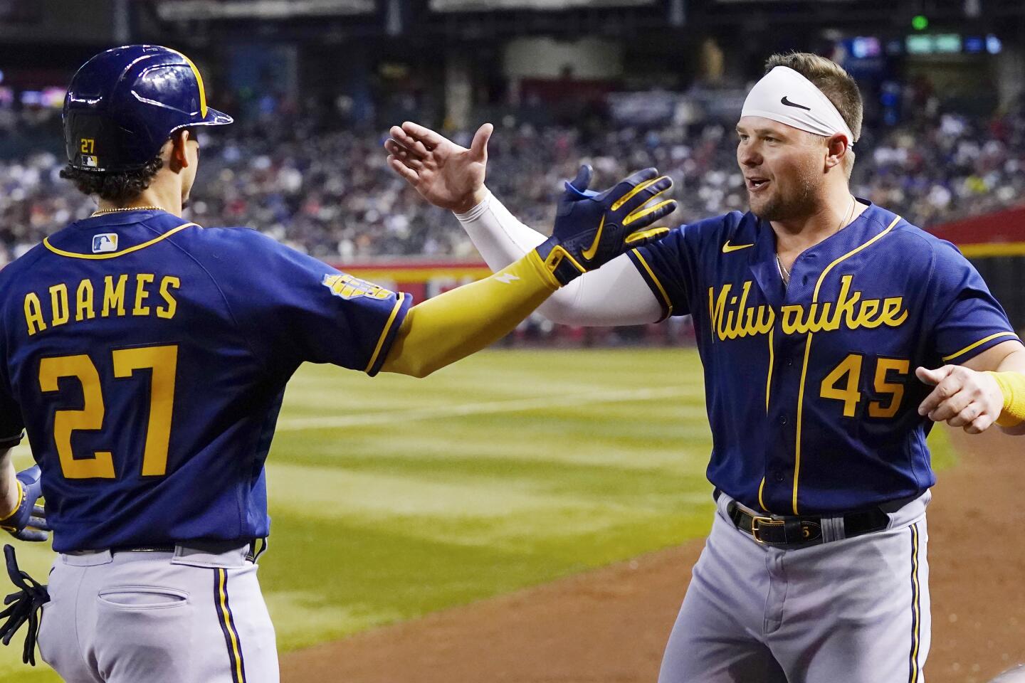 Milwaukee Brewers' Willy Adames, right, celebrates after his base