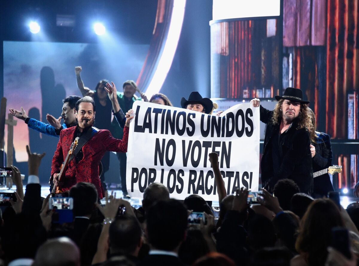 Los Tigres del Norte and rockers Maná hold up a sign that translates to: "Latinos United, Don't Vote For Racists" at the end of their performance at the 16th Latin Grammy Awards at the MGM Grand Garden Arena in Las Vegas.