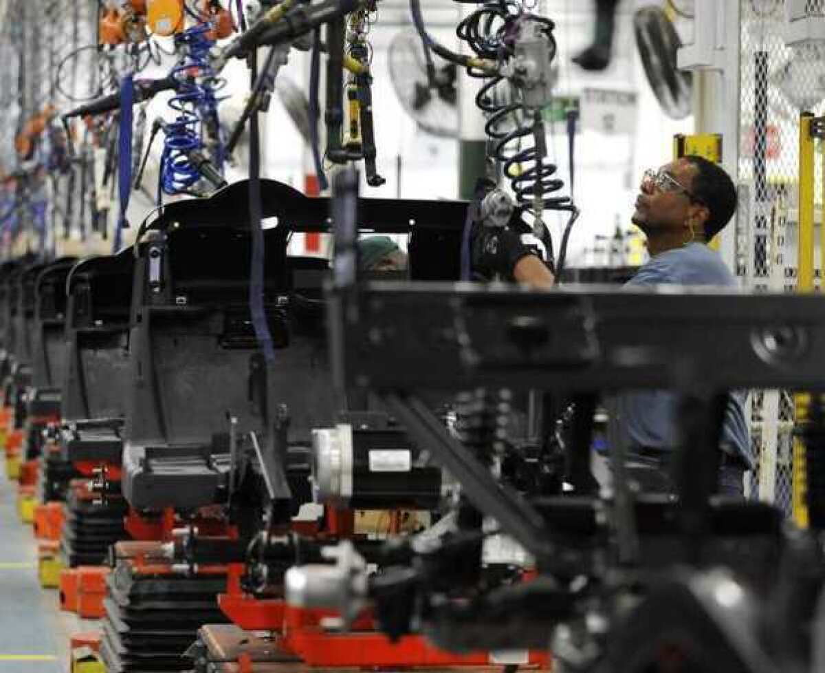 Assembler Barry Austin works on a golf car production line at the E-Z-GO plant in Augusta, Ga. U.S. factory activity shrank for the third straight month in August as new orders, production and employment all fell.