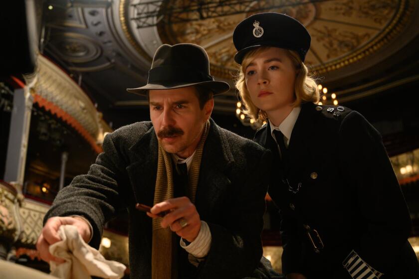 This image released by Searchlight Pictures shows Sam Rockwell and Saoirse Ronan in a scene from "See How They Run." (Parisa Taghizadeh/Searchlight Pictures via AP)