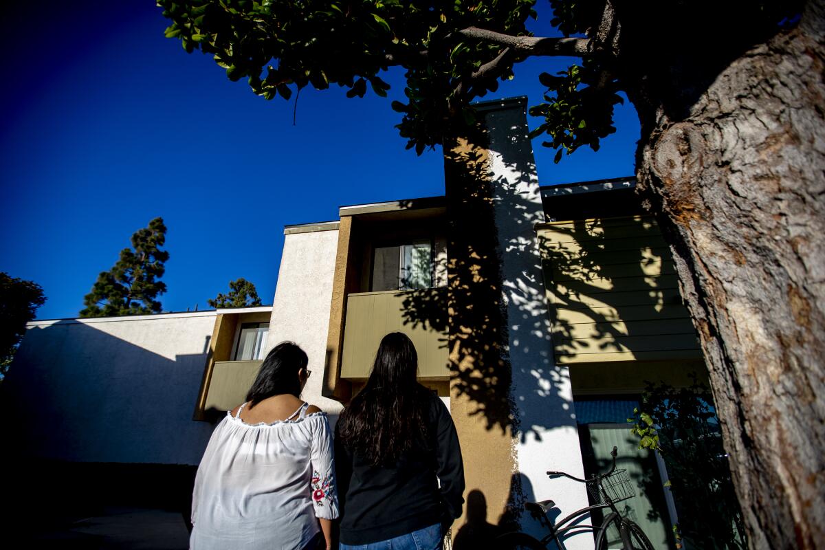 Two women walking to an apartment building.