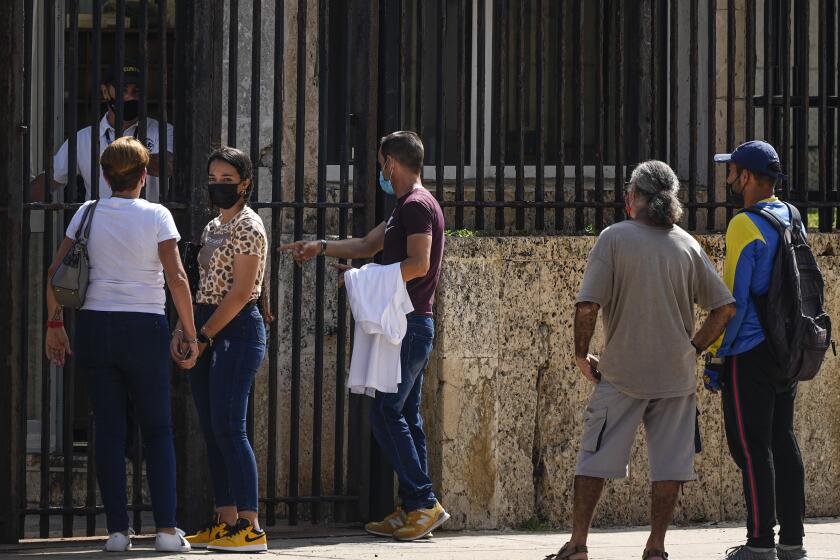 People wait their turns outside the U.S. embassy the day after it reopened its consular services in Havana, Cuba, Wednesday, May 4, 2022. (AP Photo/Ramón Espinosa)