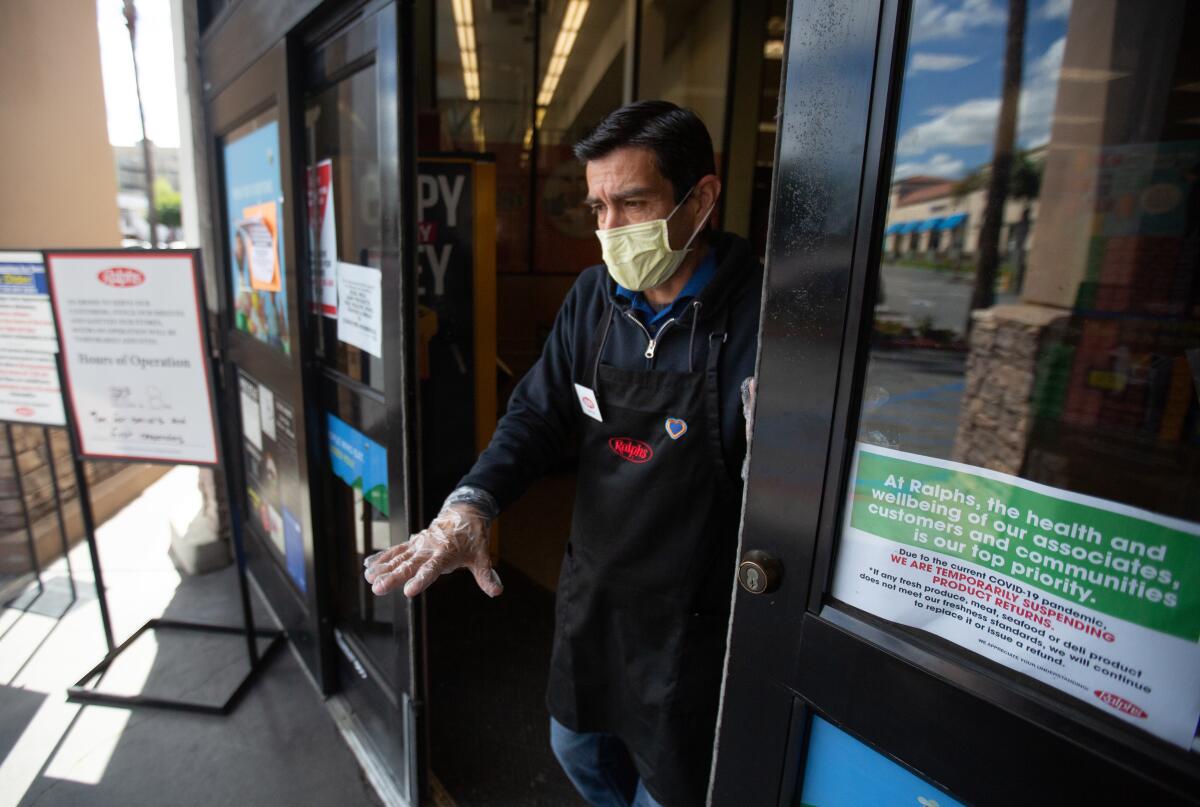 An employee at the door of a Ralphs grocery store in Westchester.