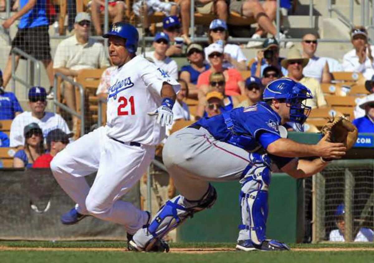 Juan Rivera scores past Texas Rangers catcher Chris Robinson in the sixth inning of a spring training game on March 16.