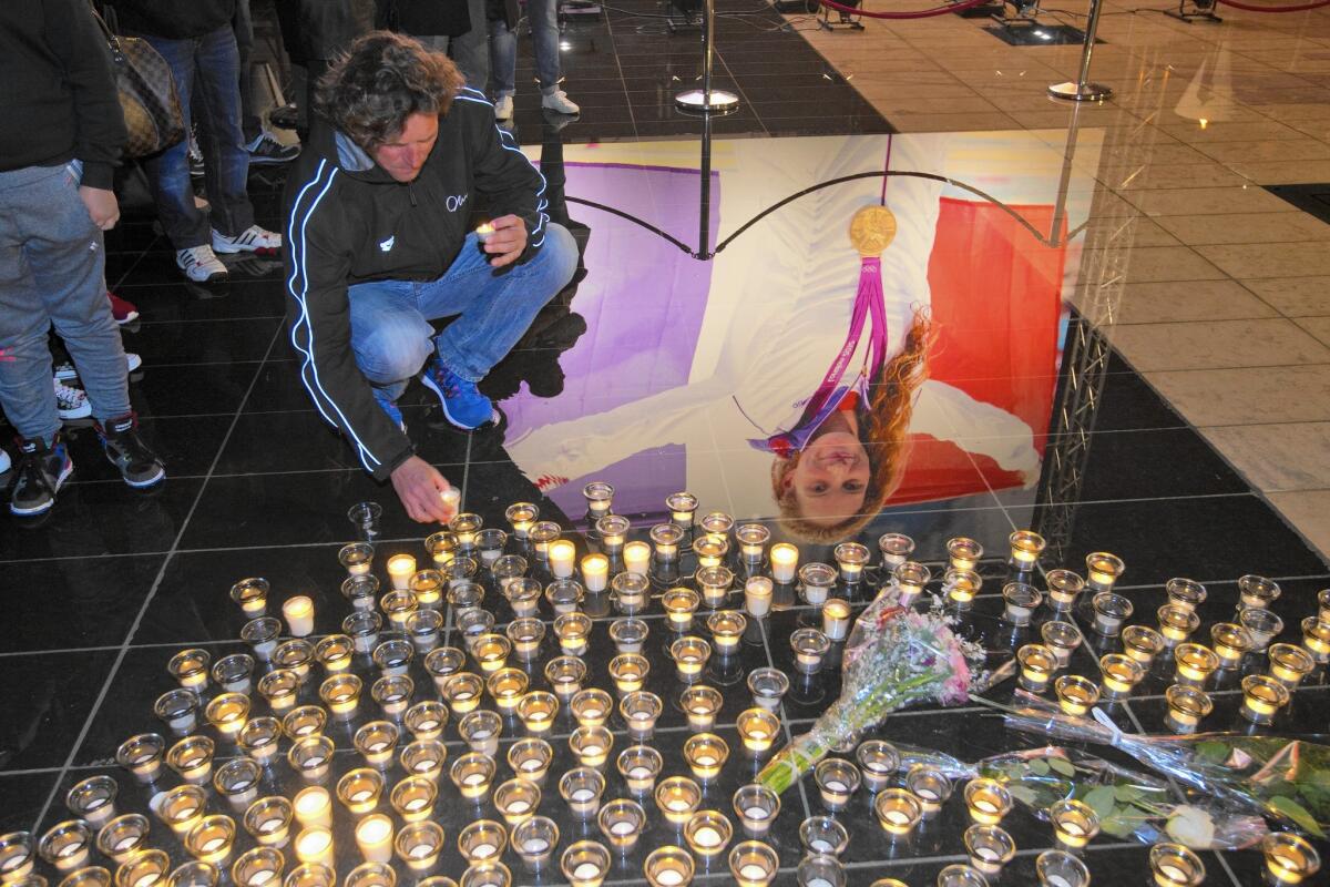 A man places candles to pay homage to Olympic gold medalist swimmer Camille Muffat on March, 10, 2015, in Nice, southeastern France. Argentine recovery teams arrived on March 10 at the site of a helicopter collision to recover the bodies of 10 people, including Muffat, 25, who was participating in a reality TV show.