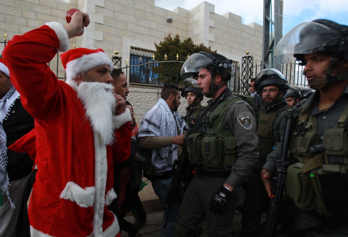 A costumed Palestinian argues with Israeli security forces at a Bethlehem rally against Israeli settlements on Dec. 23.