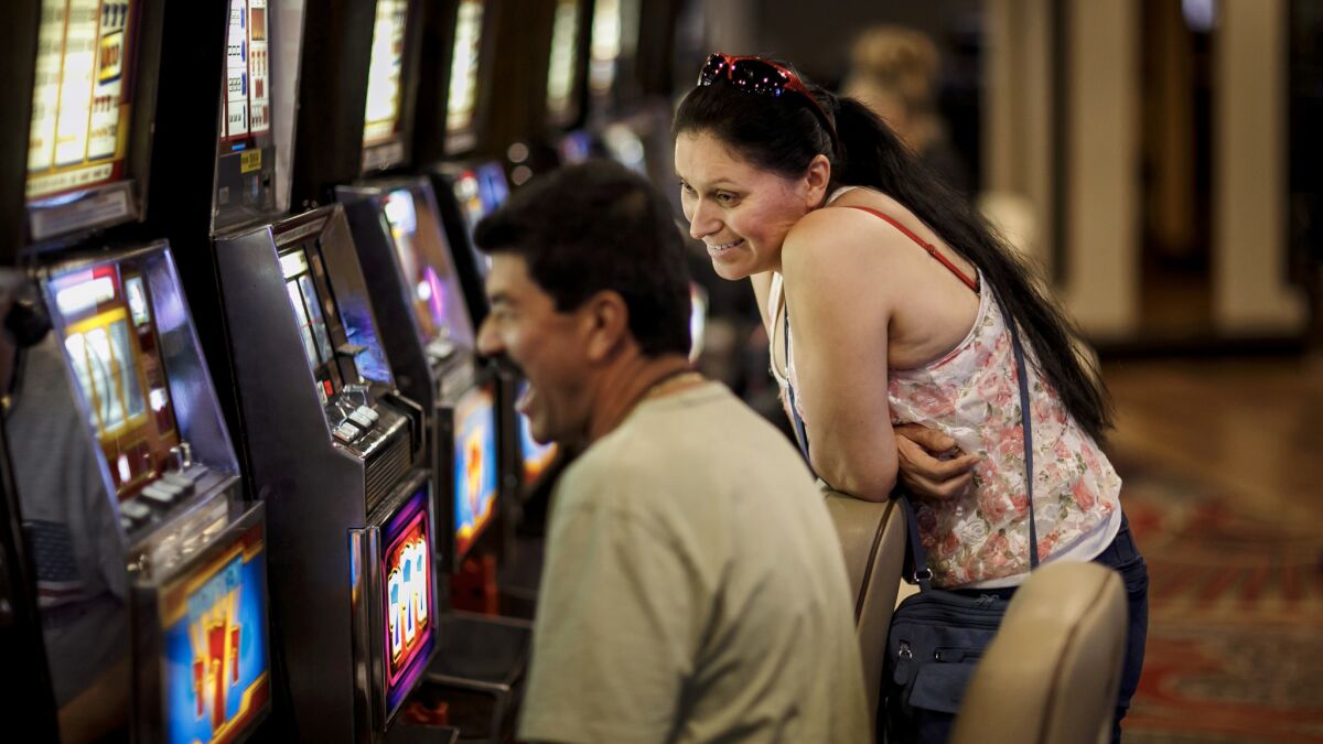 Eduardo Leon and Sandra Cardenas, from Miami, play one of the last remaining coin slot machines at Circus Circus Hotel & Casino in Las Vegas.