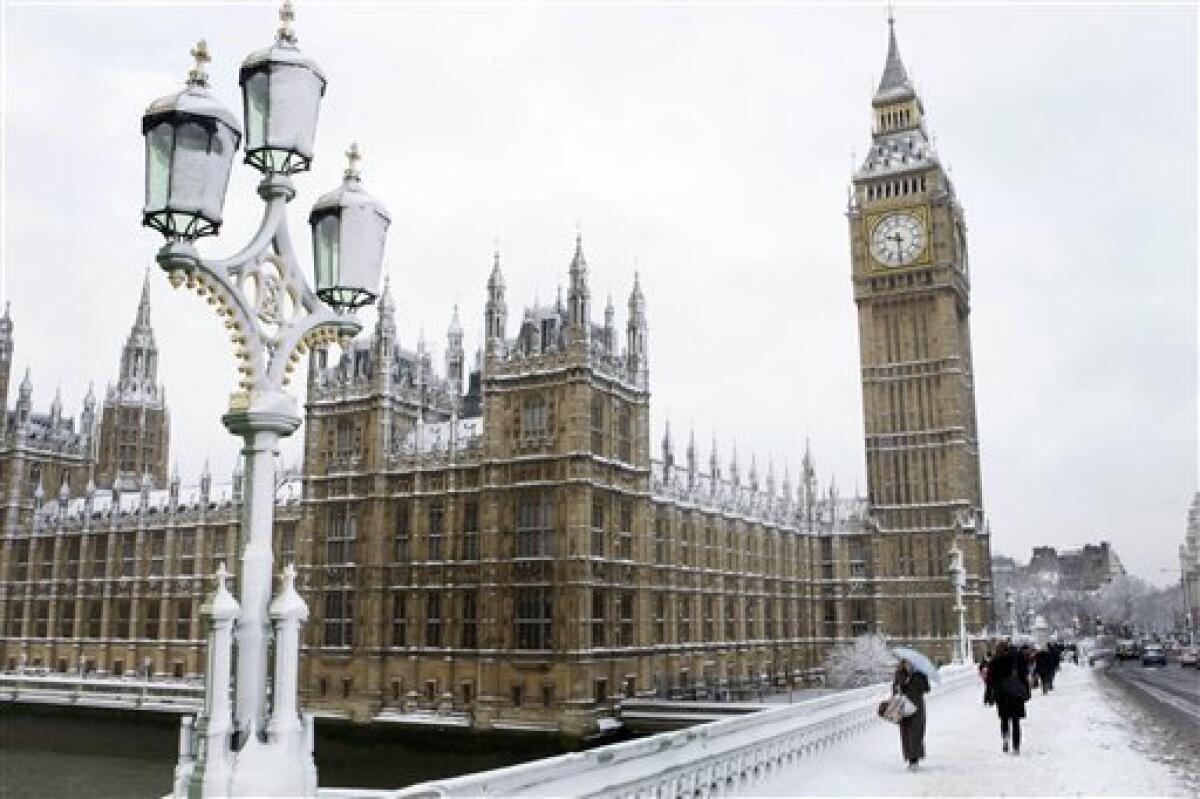Commuters walk over Westminster Bridge, in London, Monday, Feb. 2, 2009. Heavy snowfall in much of Britain caused widespread travel problems throughout the country Monday morning, causing hundreds of flight cancellations and rush hour chaos in London. (AP Photo/Joel Ryan)
