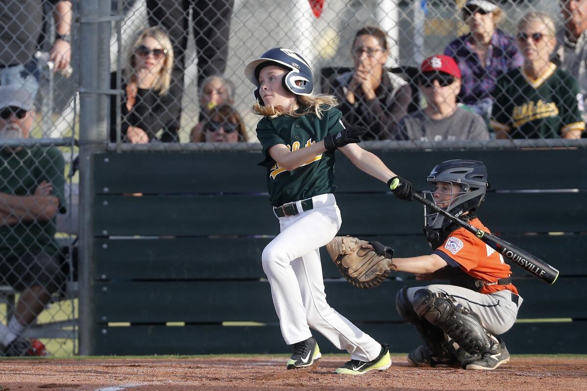 Costa Mesa American Little League's Bennett Molica singles in the tying the run against Ocean View in a District 62 Tournament of Champions Major Division quarterfinal game on Tuesday at Costa Mesa American Little League.