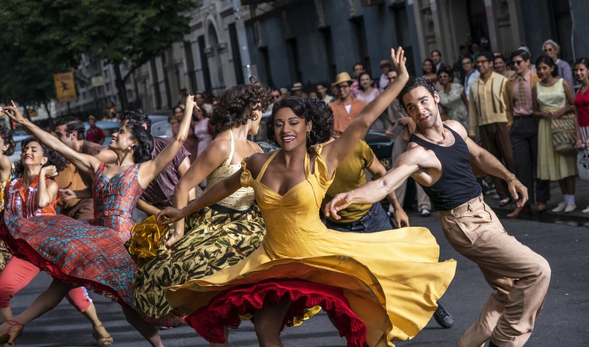 Enthusiastic dancers in colorful costumes  in the 2021 remake of "West Side Story."