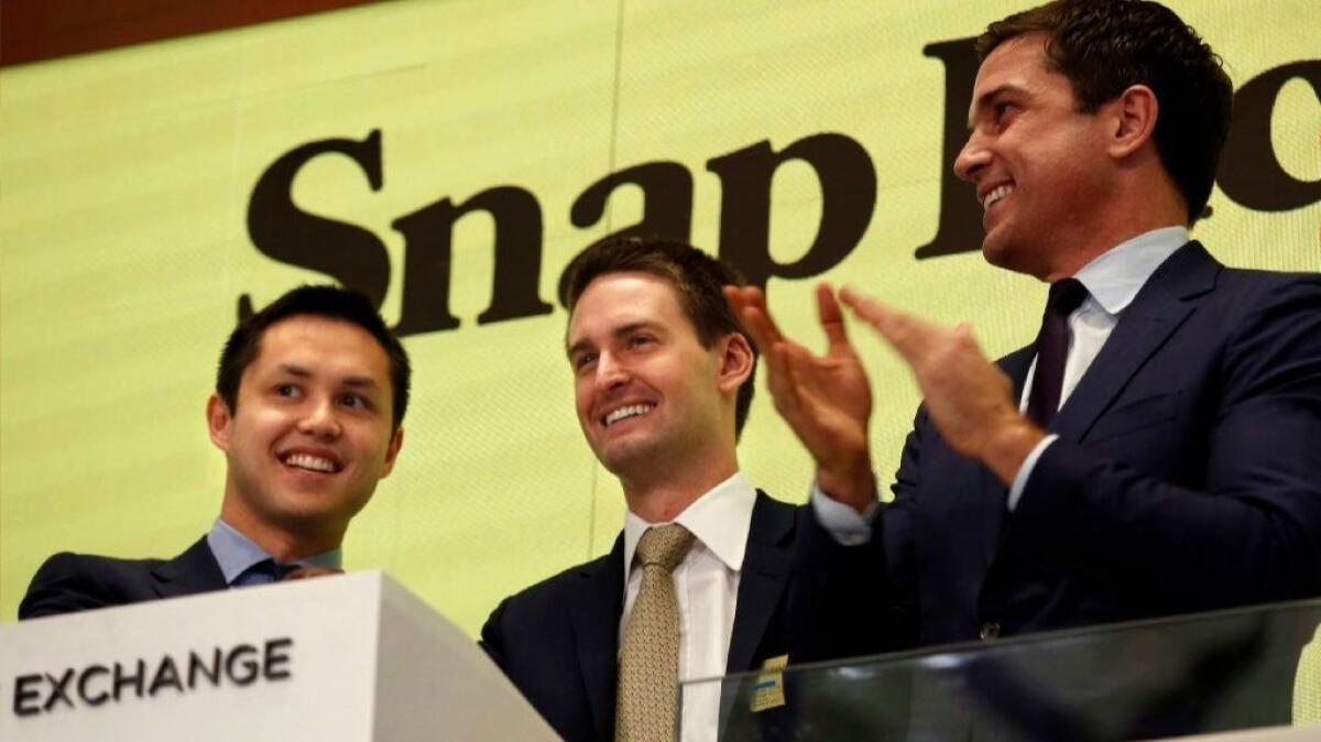 Snap Inc. CEO Evan Spiegel, center, rings the bell at the New York Stock Exchange for his company's public market debut in March, along with colleague Bobby Murphy, left, and NYSE President Thomas Farley.