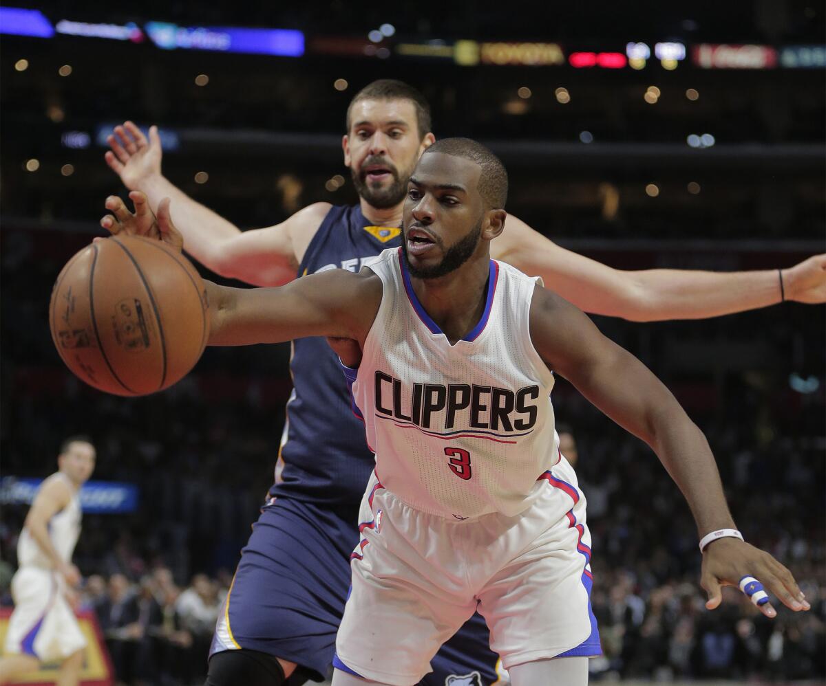 Clippers point guard Chris Paul grabs an offensive rebound in front of Grizzlies center Marc Gasol in the second half.