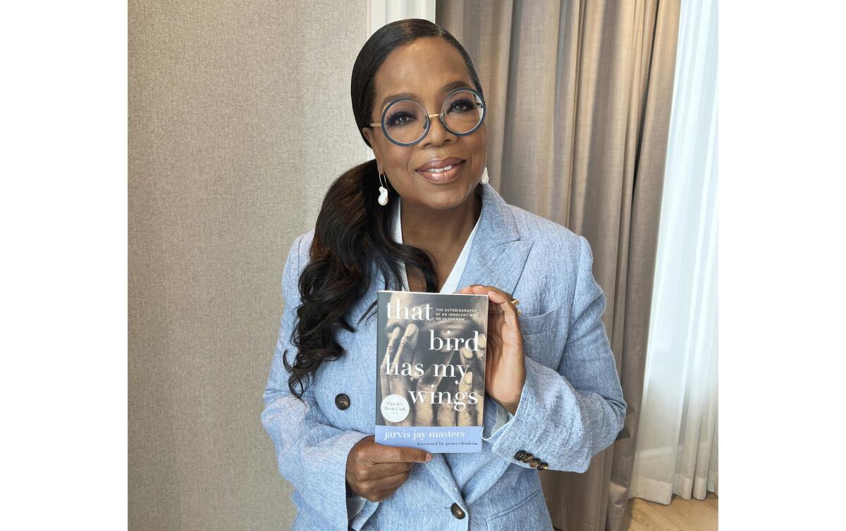 Oprah Winfrey holds up "That Bird Has My Wings" by California death row inmate Jarvis Jay Masters.