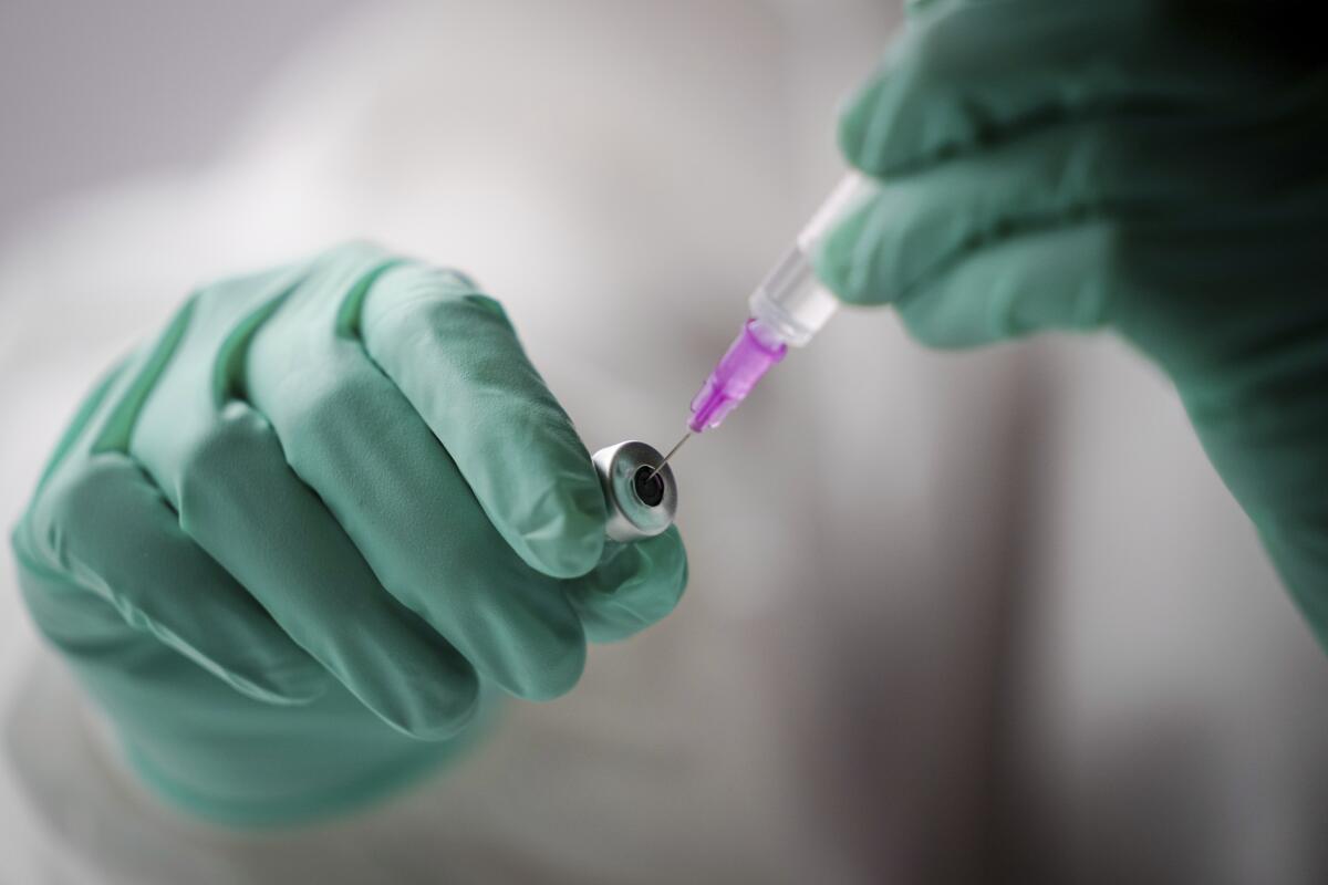Un empleado extrae una jeringa con la vacuna de Pfizer-BioNTech contra el COVID-19 