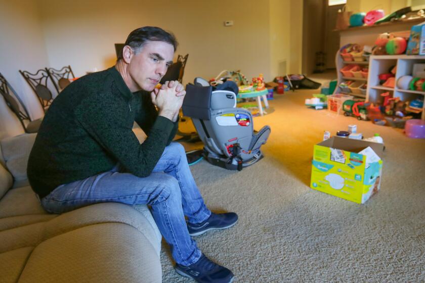 Ken Burnett sits in the living room of his Kearny Mesa apartment full of children's toys his son, Rowan Burnett, 3, and daughter, Mia Burnett, 1, play with or use, January 29, 2020 in San Diego, California. His wife, Ynjun Wei, son and daughter are stuck in Wuhan, China, because of the Coronavirus outbreak. They have been there since November, and were planning on coming back to San Diego next week.