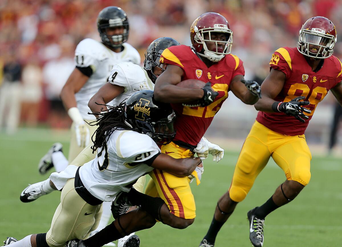 Trojans tailback Justin Davis is brought down by Idaho's Dorian Clark after a long gain in the first quarter Saturday.