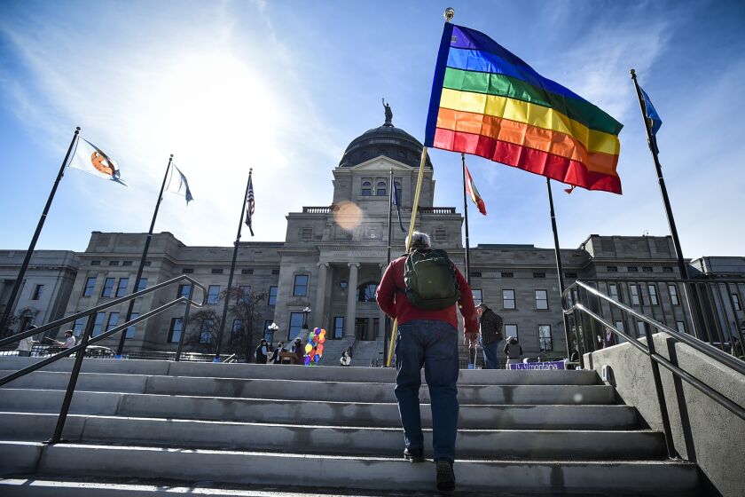 FILE - Demonstrators gather on the steps of the Montana state Capitol protesting anti-LGBTQ+ legislation in Helena, Mont., March 15, 2021. More than two dozen Republican Montana lawmakers are co-sponsoring a bill that would allow students to misgender and dead-name their transgender peers in a move that has alarmed LGBTQ activists and others who argue it would allow the bullying of a population of kids already struggling for acceptance. (Thom Bridge/Independent Record via AP, File)
