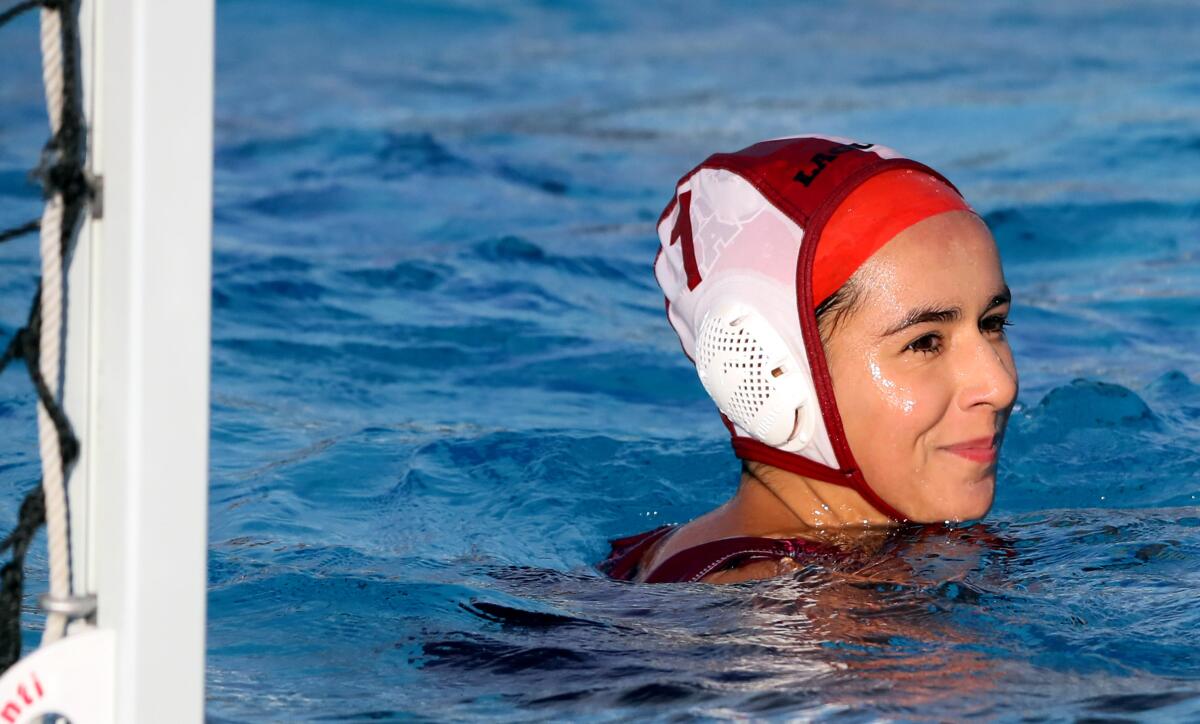Laguna Beach High girls' water polo goalie Lauren Schneider smiles after scoring a goal from her net at Newport Harbor.