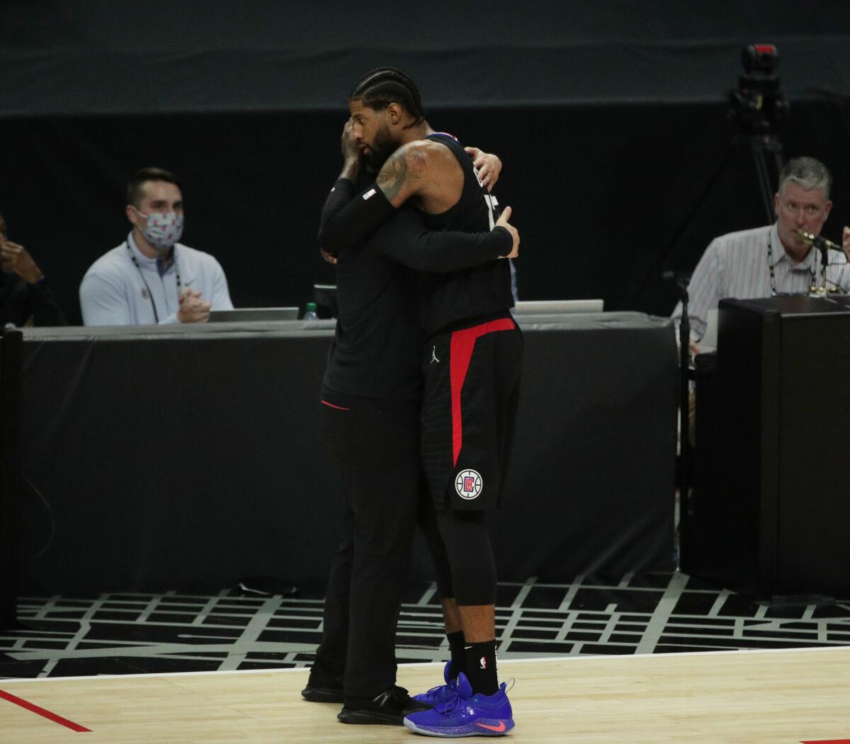 Clippers forward Paul George and coach Tyronn Lue embrace in the final moments of the season-ending loss to the Phoenix Suns.