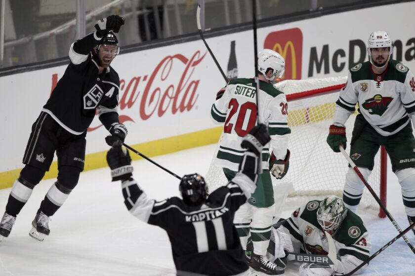 Los Angeles Kings center Jeff Carter, left, celebrates his goal with center Anze Kopitar, second from left, of Solvania, against Minnesota Wild goaltender Cam Talbot, second from right, defenseman Ryan Suter, center, and center Marcus Johansson, right, of Sweden, during the first period of an NHL hockey game in Los Angeles, Thursday, Jan. 14, 2021. (AP Photo/Alex Gallardo)