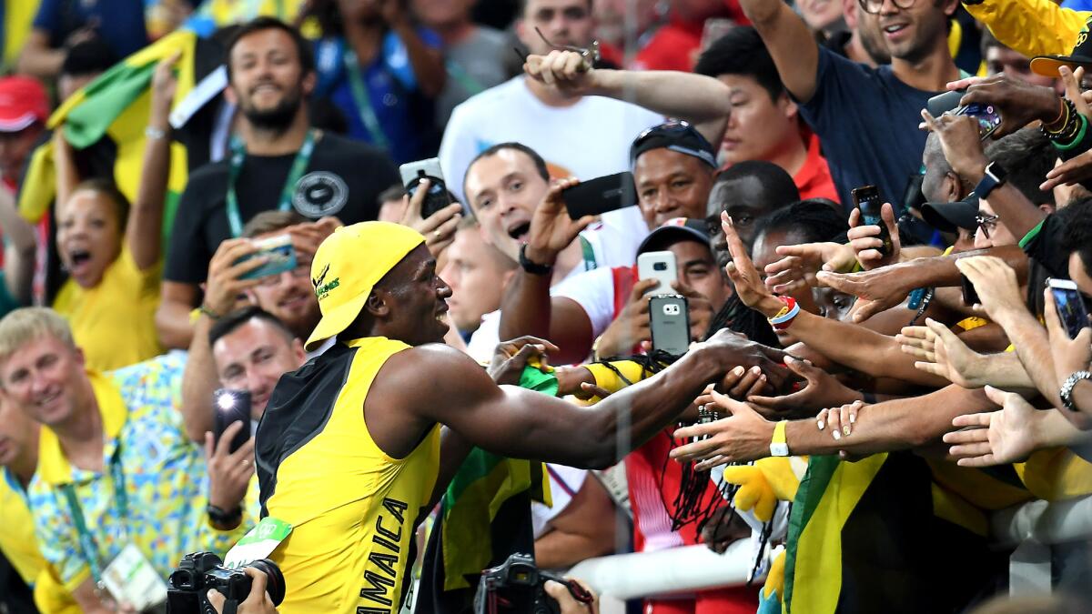 Usain Bolt celebrates with spectators after winning the gold medal in the 100-meter dash on Sunday.
