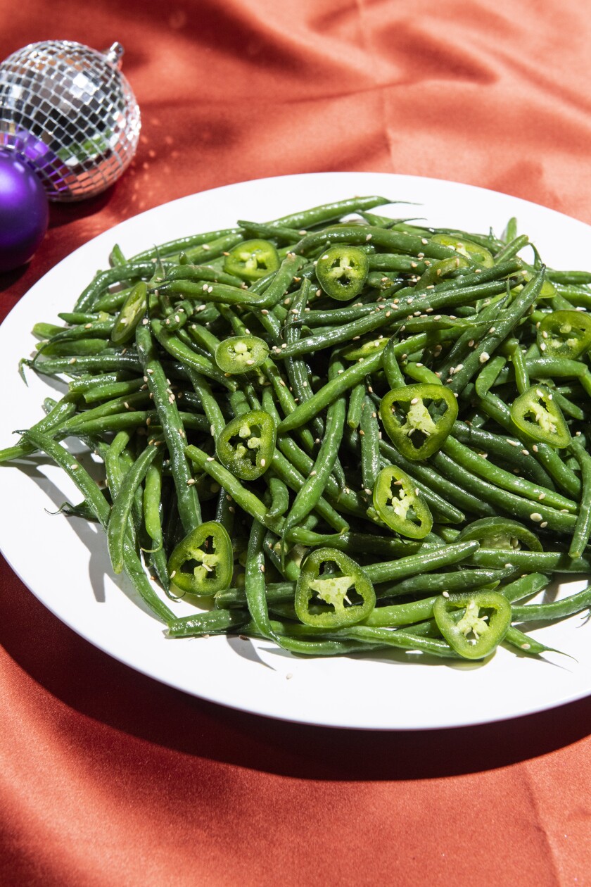 A plate of French green beans with jalapeño slices and sesame seeds