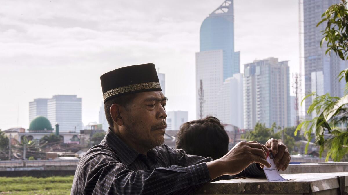 An man casts his ballot in the governor's election at a polling station in Jakarta, Indonesia, on Wednesday.