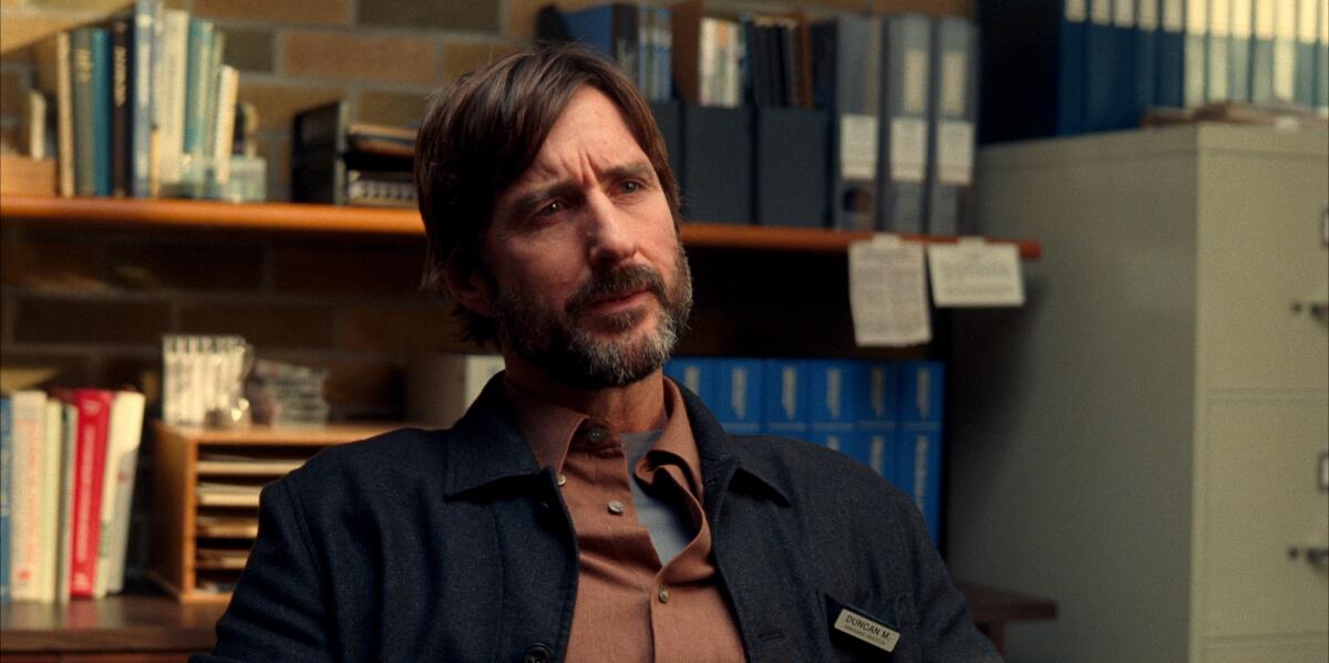 A bearded man speaks in an office.