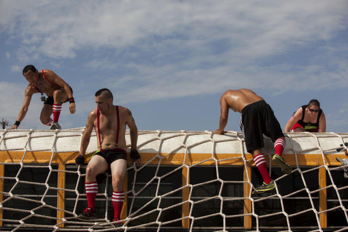 Runners scale an obstacle in the Concrete Hero race, benefiting AIDS Project L.A., in June.