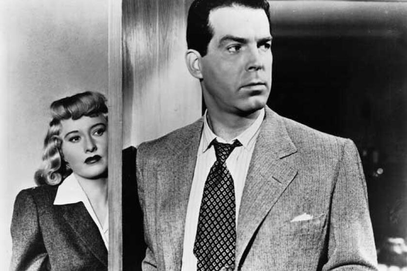 Barbara Stanwyck stands behind Fred MacMurray in 1944's "Double Indemnity" on TCM.