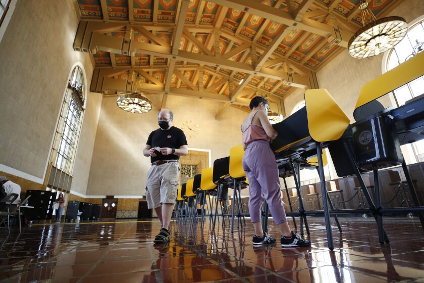LOS ANGELES, CA - SEPTEMBER 13: Josh Hodas, left, and partner Serena Delgadillo, right, are among people casting their votes Monday morning in the historic Los Angeles Union Station Ticket Hall or Main Concourse built in 1939 as the largest railroad passenger terminal in the Western United States. The Union Station Hall is serving as a Vote Center for the recall effort against California Governor Gavin Newsom. Union Station on Monday, Sept. 13, 2021 in Los Angeles, CA. (Al Seib / Los Angeles Times).