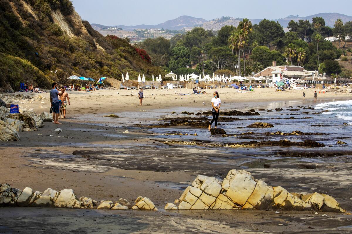 A woman has her picture taken at Paradise Cove in Malibu.