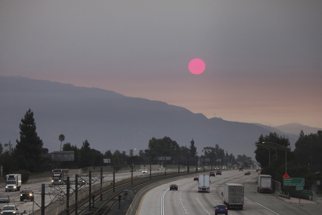 Smoke from wildfires burning east of Los Angeles dims the sunrise