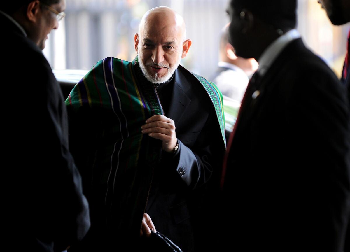 Afghan President Hamid Karzai, center, arrives at a news conference in Colombo, Sri Lanka, while on a state visit.