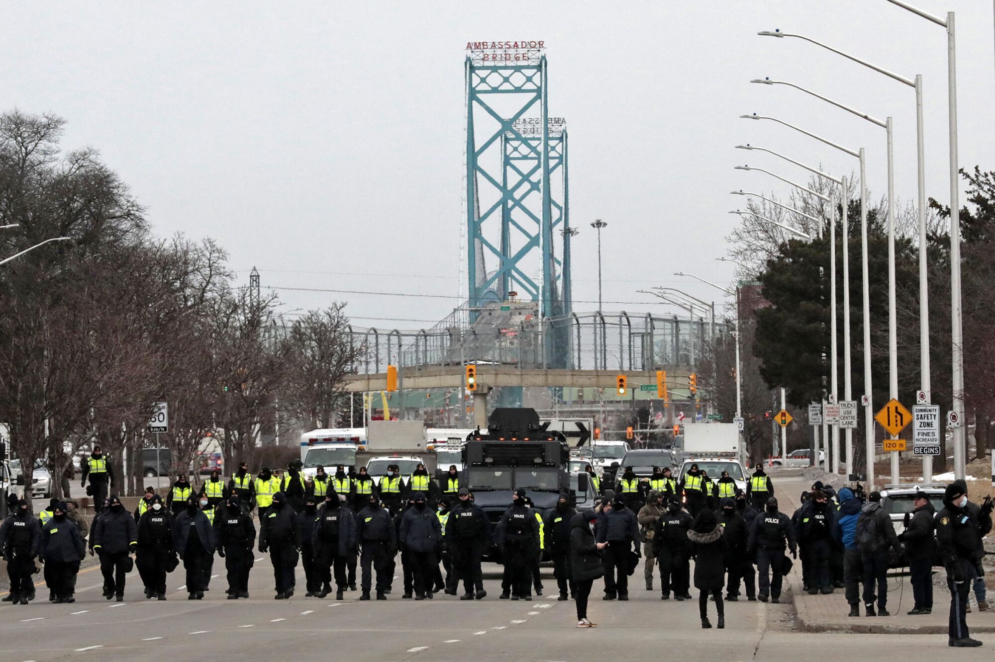 Police line up across a street near Ambassador Bridge 