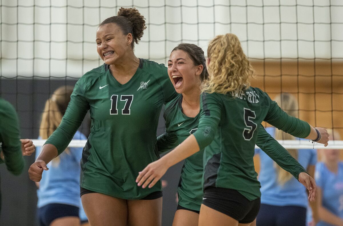 Sage Hill's Brooke Thomassen, center, celebrates a point with Cydnee Bryant, left, and Soraya Dennis, right, against CdM.