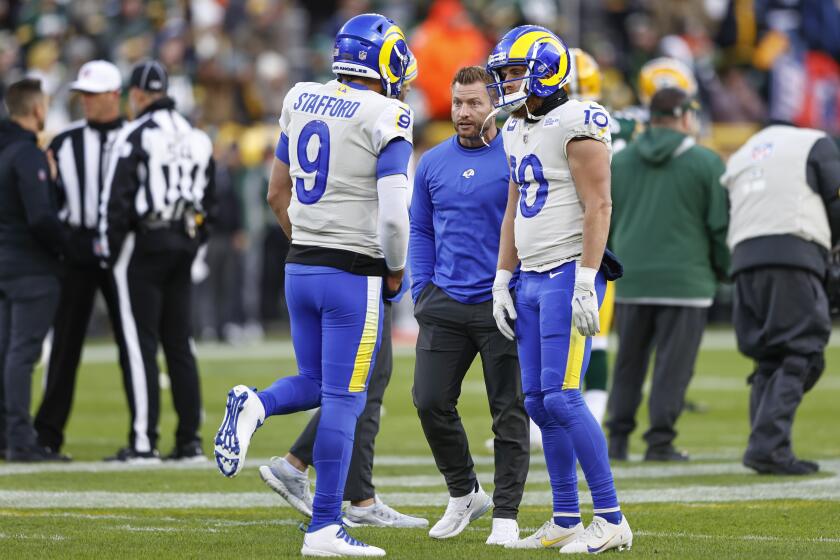 Los Angeles Rams head coach Sean McVay, center, talks with quarterback Matthew Stafford (9) during warmups prior to an NFL football game against the Green Bay Packers, Sunday, Nov. 27, 2021, in Green Bay, Wis. (AP Photo/Kamil Krzaczynski)