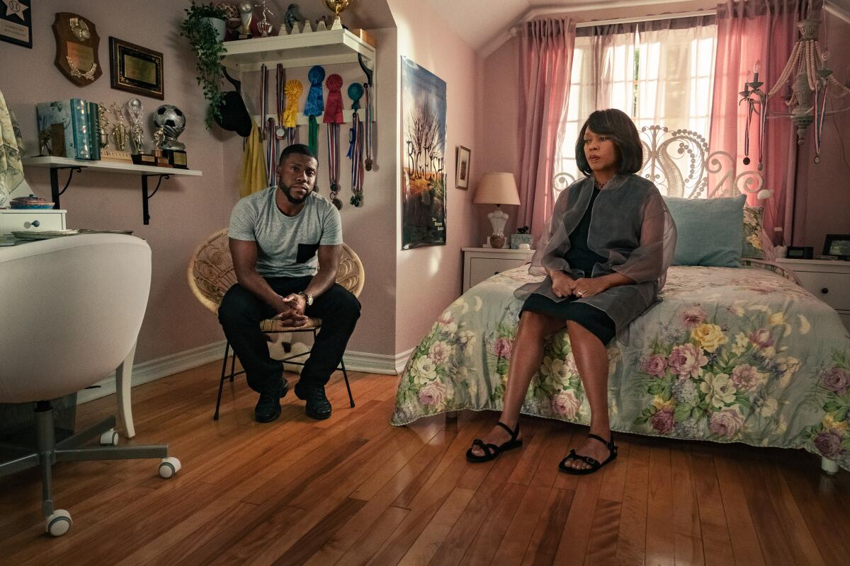 Kevin Hart as Matt and Alfre Woodard as Marion in a bedroom with awards and ribbons on the wall in 'Fatherhood.'