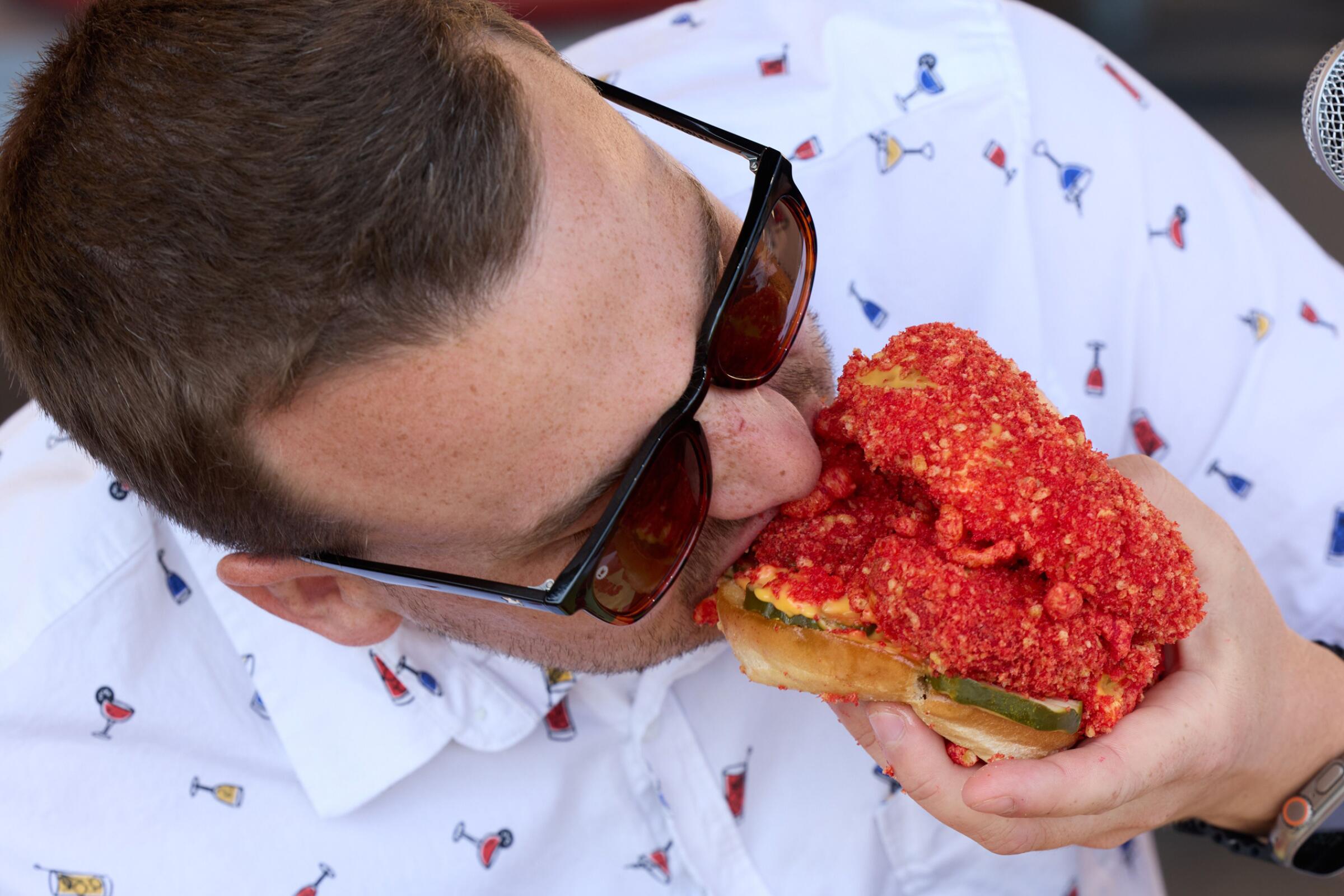 A judge eats Biggy's Hot Cheeto Chicken Sandwich during the Fair-Tastic Food Competition at the 2023 San Diego County Fair.