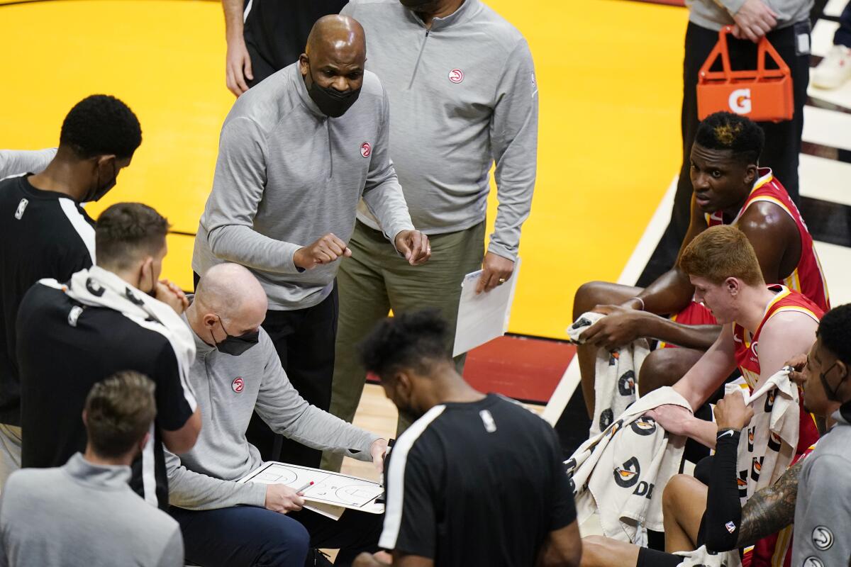 Atlanta Hawks interim coach Nate McMillan, center, gestures as he talks to players during a timeout in the first half of the team's NBA basketball game against the Miami Heat, Tuesday, March 2, 2021, in Miami. His opportunity to return to a head coach position comes with mixed feelings following Monday's firing of his friend, Lloyd Pierce. (AP Photo/Wilfredo Lee)