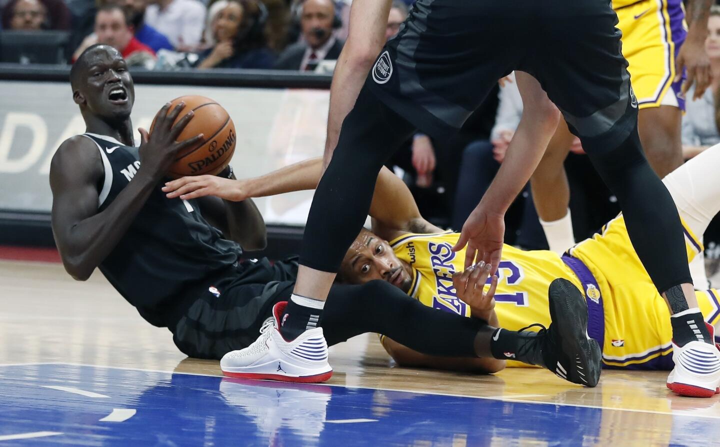 Los Angeles Lakers forward Johnathan Williams (19) and Detroit Pistons forward Thon Maker (7) try to control the loose ball during the first half of an NBA basketball game, Friday, March 15, 2019, in Detroit. (AP Photo/Carlos Osorio)