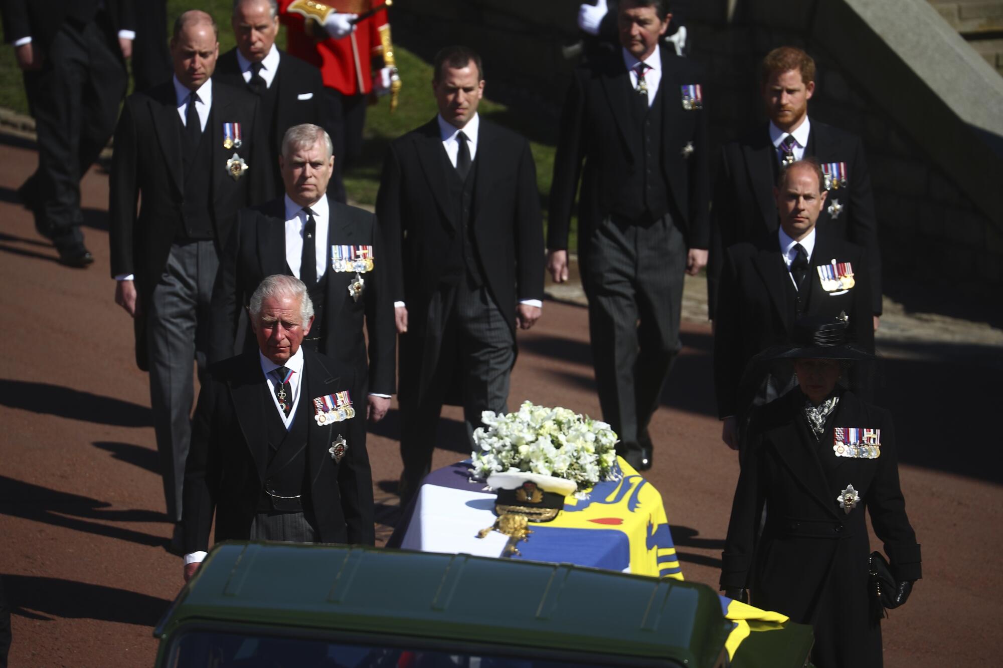 Members of the royal family walk behind the coffin of Prince Philip as it is driven at Windsor Castle.