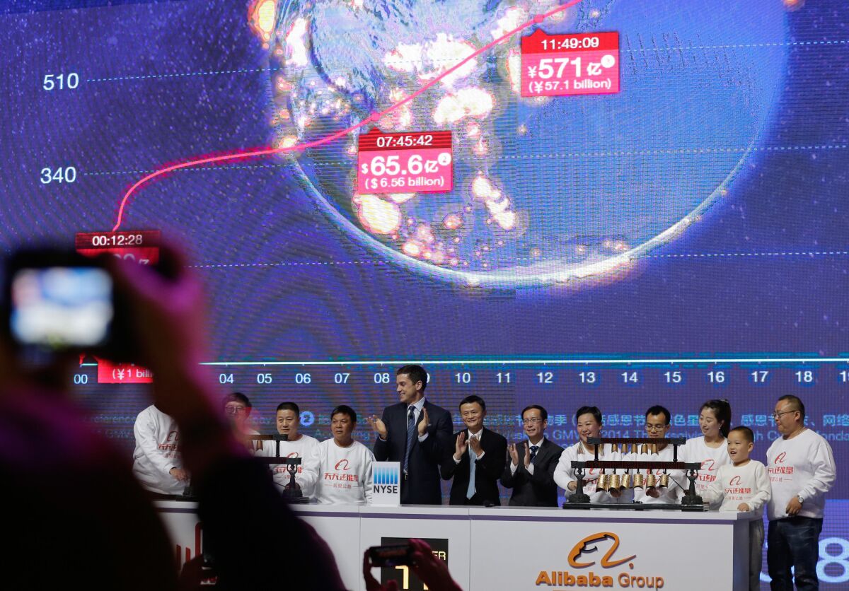 Alibaba Group's Jack Ma and Tom Farley, CEO of the New York Stock Exchange, applaud as invited guests ring the bell remotely to open the NYSE in front of a giant screen showing real-time Single's Day sales figures.