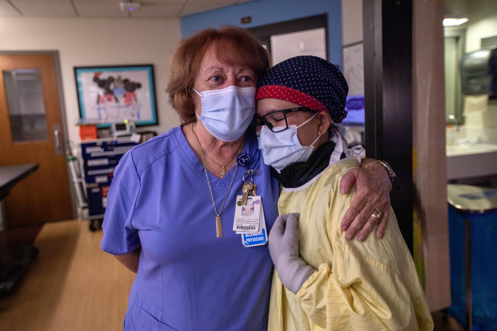 Dr. Cynthia Tinsley, left, chief of its division of pediatric critical care,  greets nurse Chovi Parenteau, right.