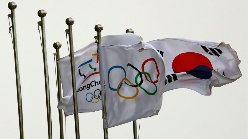 The Olympic and South Korean flags fly in strong wind during cold weather at the Pyeongchang 2018 Winter Olympic Games on Feb. 11.