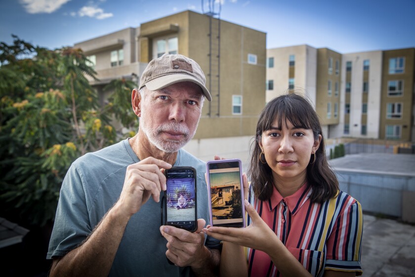 Alex Contreras, left, and his daughter Alex Contreras hold photos of him in his parents' house.